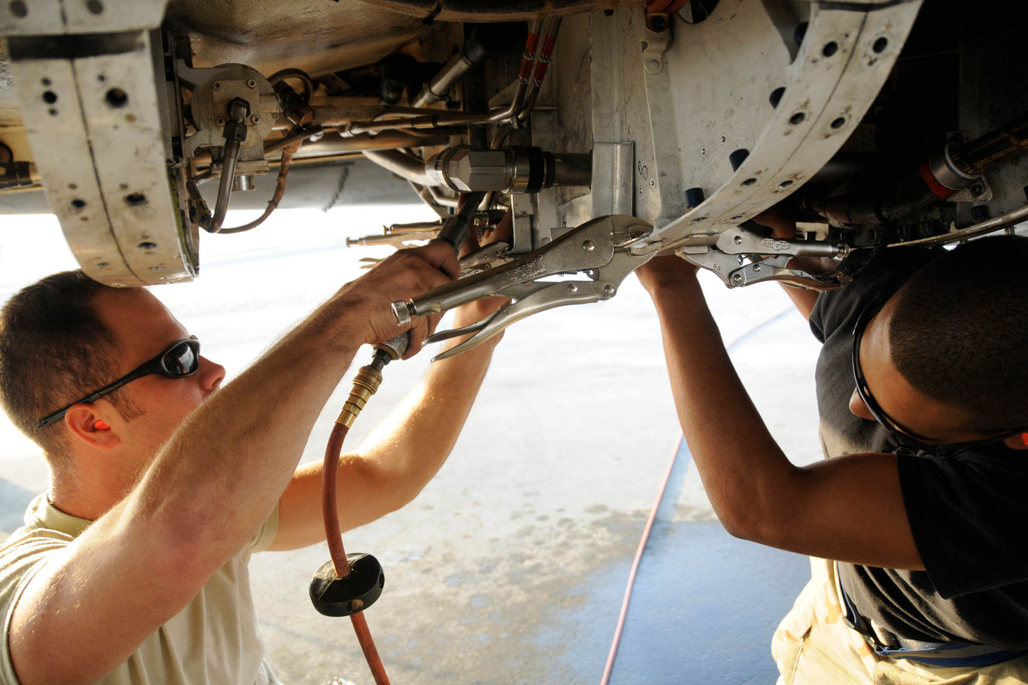 Two aircraft technicians performing structural maintenance